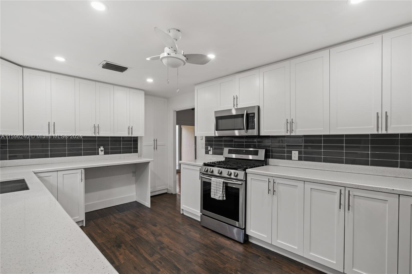 5311 Alton Road Miami Beach, FL 33140 - Photo 36 of 51 a kitchen with a sink stainless steel appliances and white cabinets