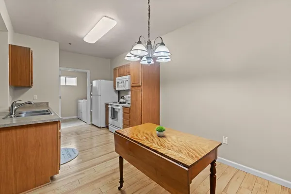 a view of a kitchen with a sink dishwasher a refrigerator and wooden floor