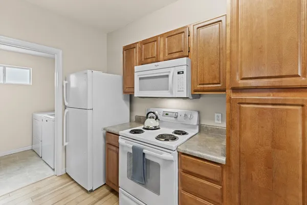 a kitchen with stainless steel appliances granite countertop white cabinets and a refrigerator