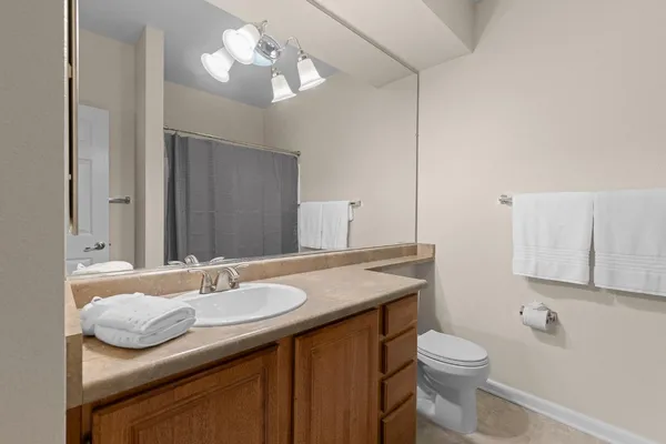 a bathroom with a granite countertop sink a toilet and a mirror
