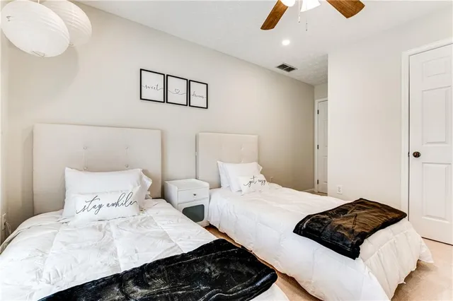 a bedroom with two beds and a large window