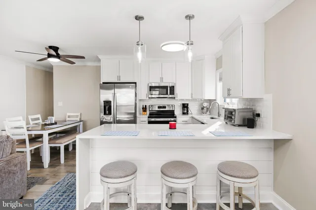 a living room with furniture a kitchen island a stove and a couches chair with the view