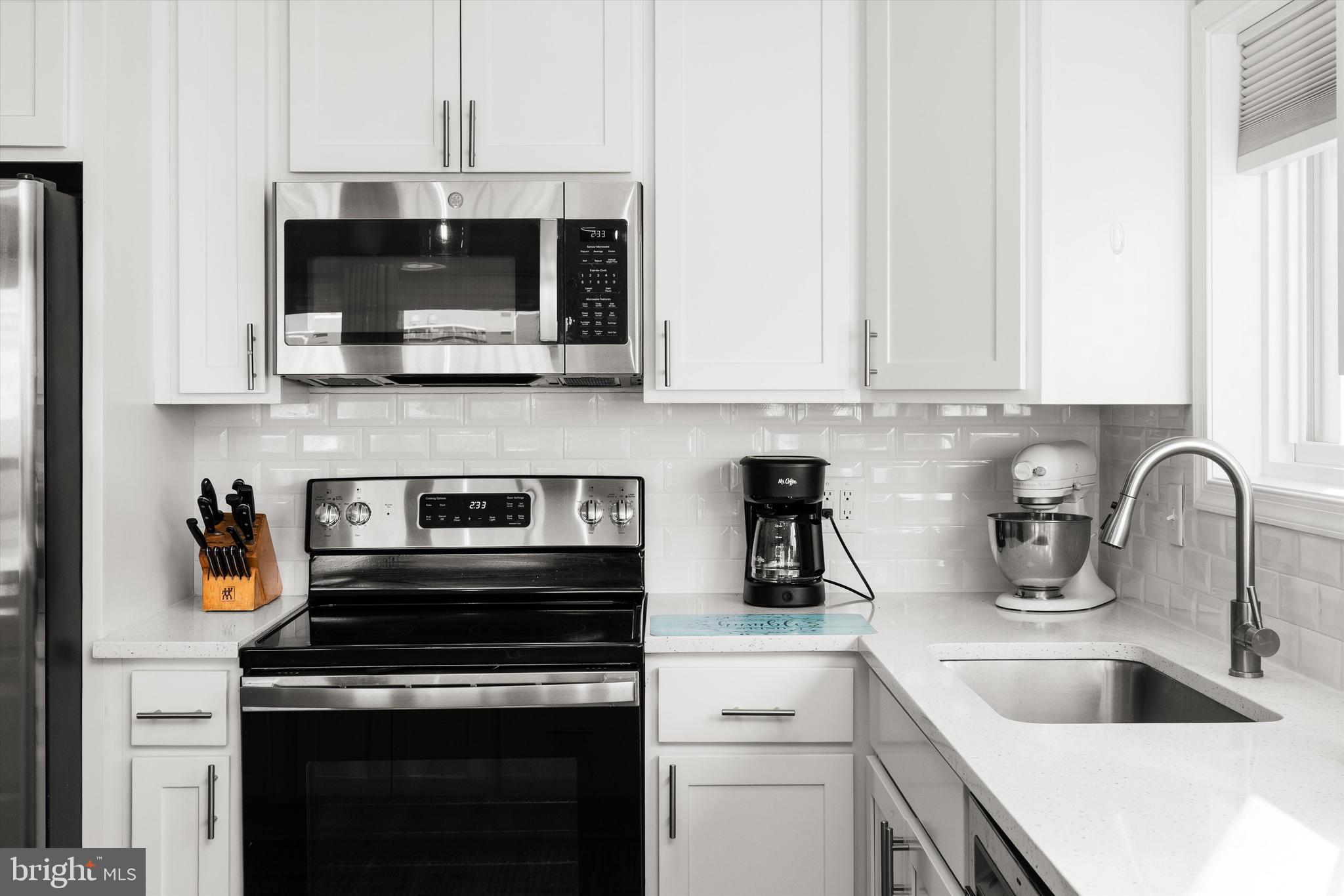 9 64th Street, Unit 304 Ocean City, MD 21842 - Photo 15 of 41 a kitchen with stainless steel appliances a stove a sink and a microwave