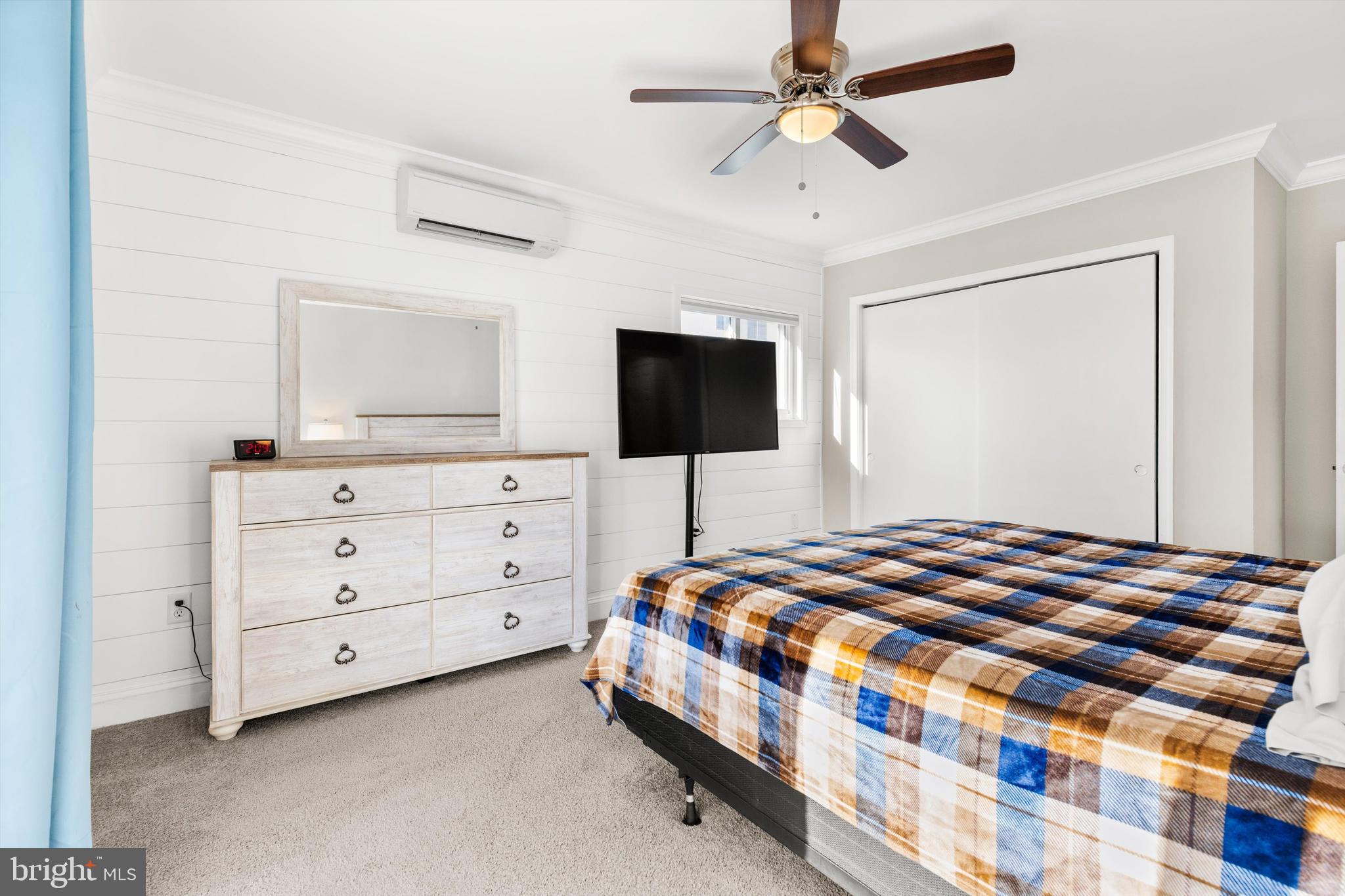 9 64th Street, Unit 304 Ocean City, MD 21842 - Photo 20 of 41 a bedroom with a bed and a flat tv screen on dresser