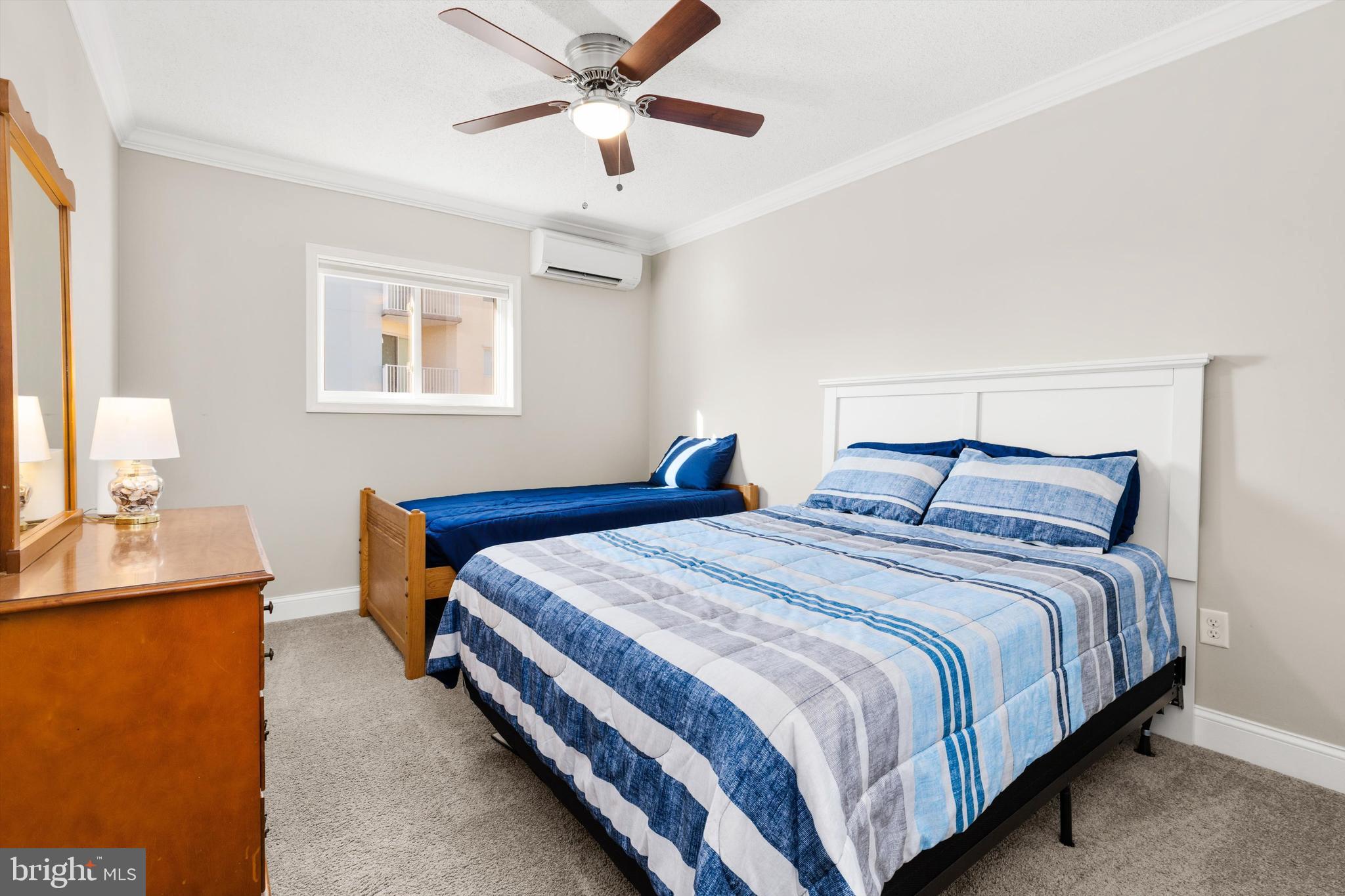 9 64th Street, Unit 304 Ocean City, MD 21842 - Photo 27 of 41 a bedroom with bed and a chandelier