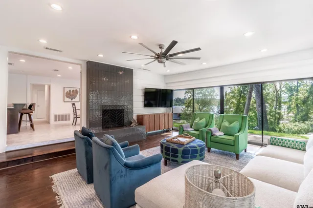 a living room with furniture fireplace and a large window
