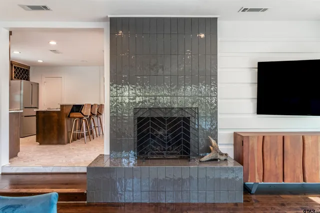 a living room with furniture a flat screen tv and a fireplace