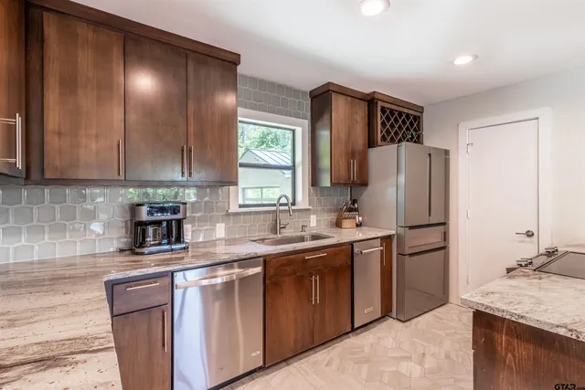 a kitchen with stainless steel appliances granite countertop a sink stove and refrigerator