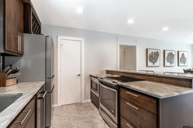 a kitchen that has a sink a stove and a refrigerator