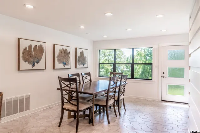 a view of a dining room with furniture a chandelier and wooden floor