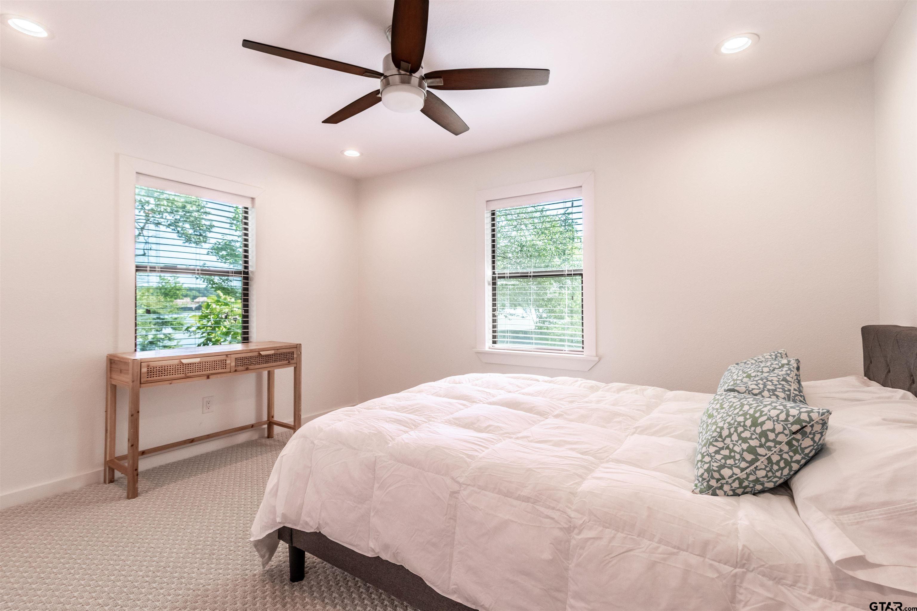 15807 North Peninsula Road Whitehouse, TX 75791 - Photo 24 of 44 a bedroom with a large bed and a chandelier