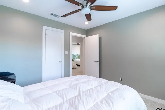 a bedroom with a bed and a ceiling fan