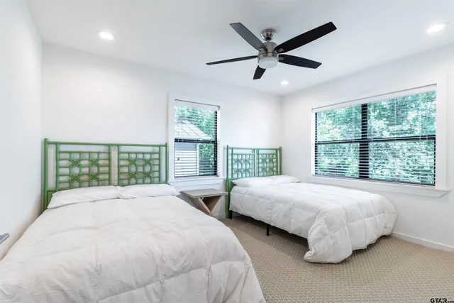 a spacious bedroom with two large bed and a large window