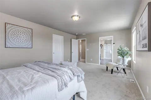 a spacious bedroom with a bed and a chair
