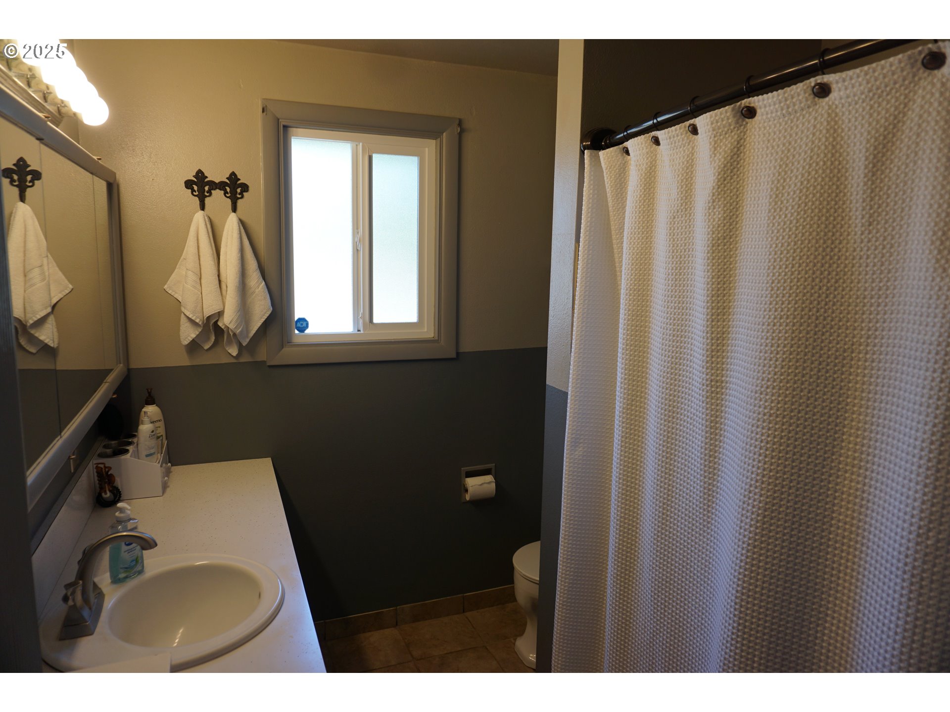 2130 Yolanda Avenue Springfield, OR 97477 - Photo 12 of 30 a bathroom with a sink a mirror a window and a shower curtain