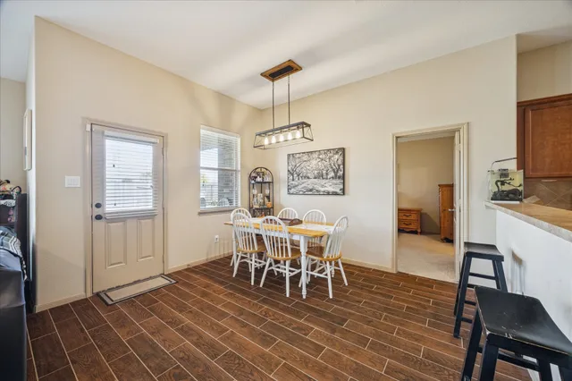 a dining room with furniture a chandelier and wooden floor