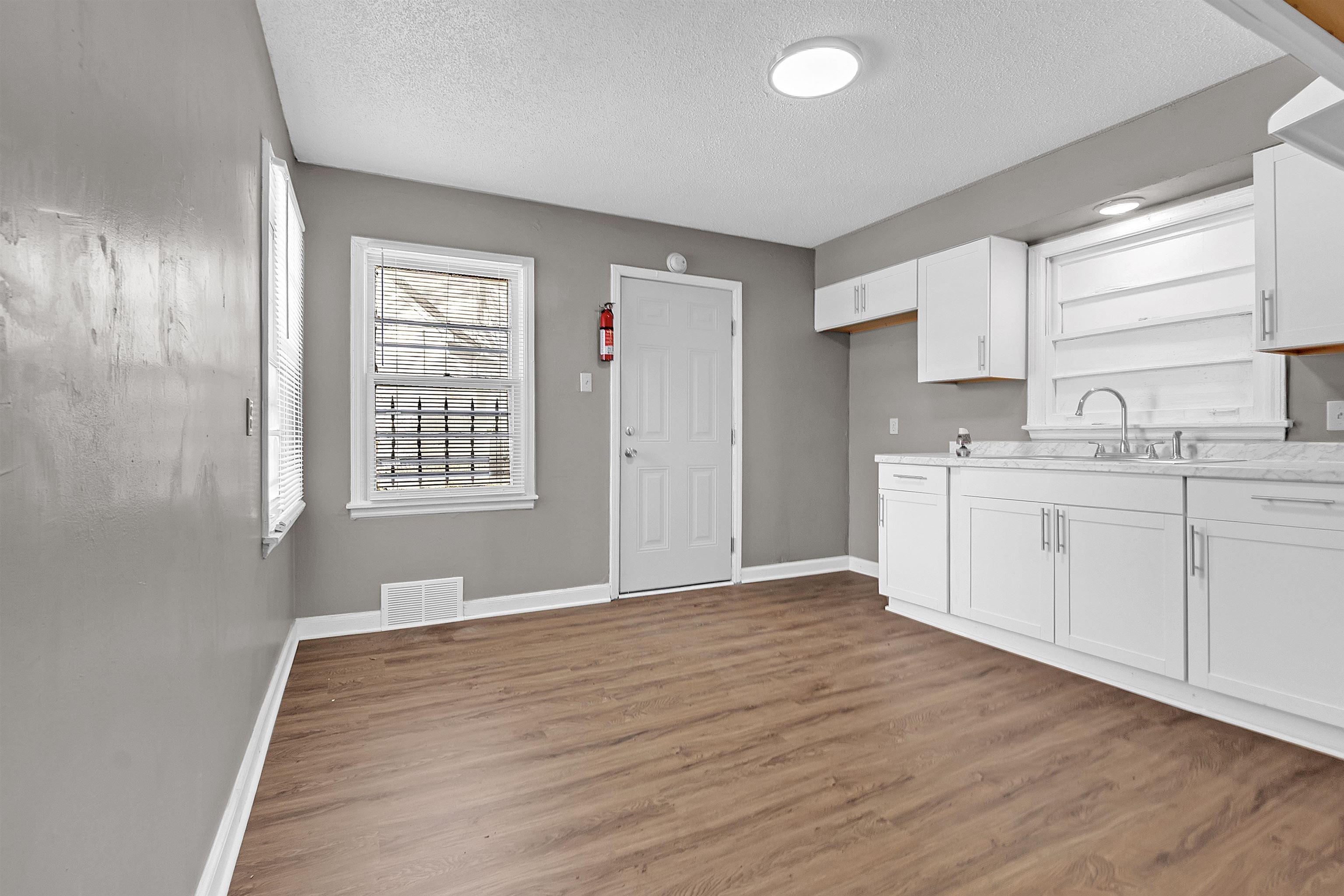 1526 Railton Road Memphis, TN 38111 - Photo 7 of 22 Kitchen with white cabinetry, light countertops, dark wood-style flooring, and a textured ceiling