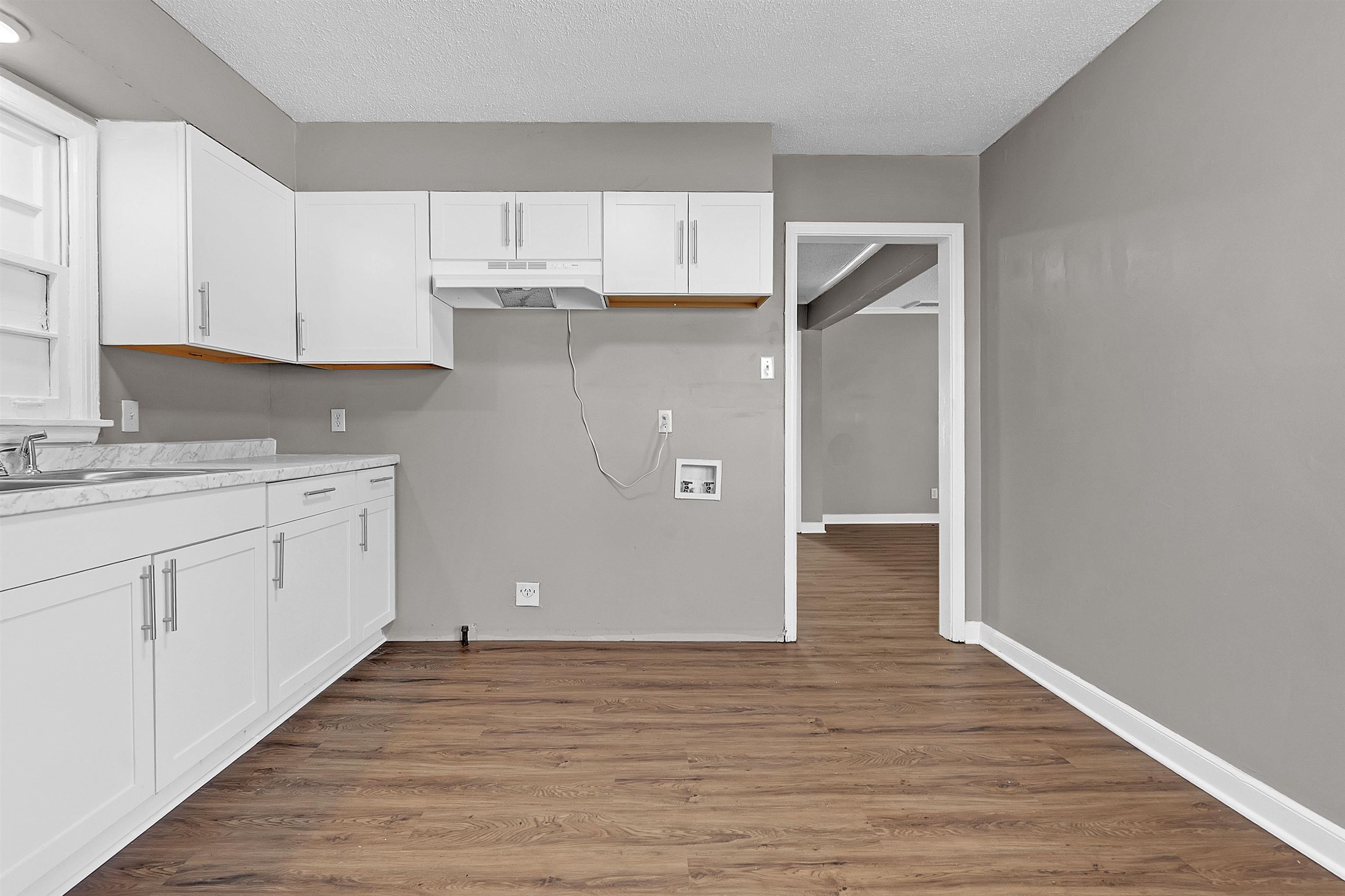 1526 Railton Road Memphis, TN 38111 - Photo 9 of 22 Kitchen with white cabinets, dark wood finished floors, light countertops, and a textured ceiling