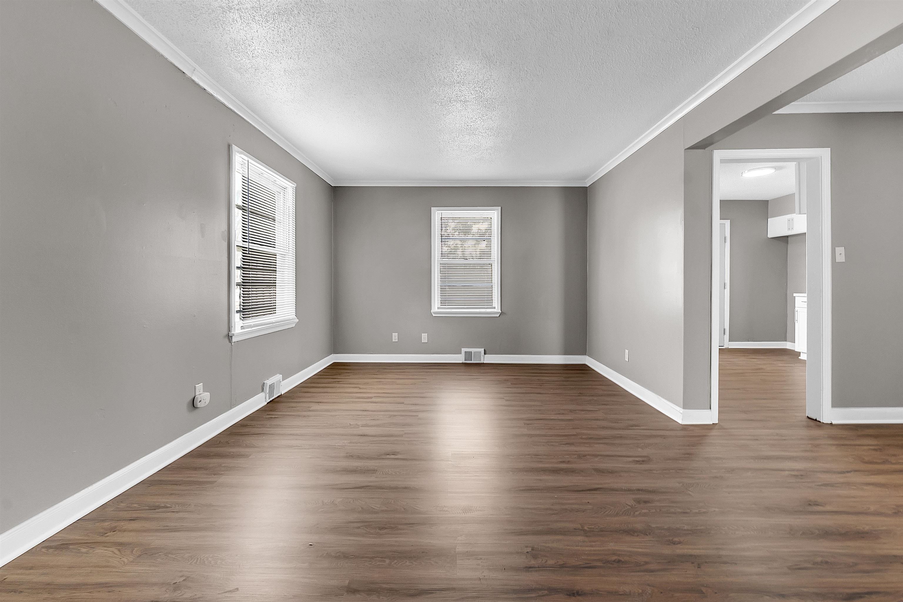 1526 Railton Road Memphis, TN 38111 - Photo 10 of 22 Empty room with a textured ceiling, dark wood-style floors, and crown molding