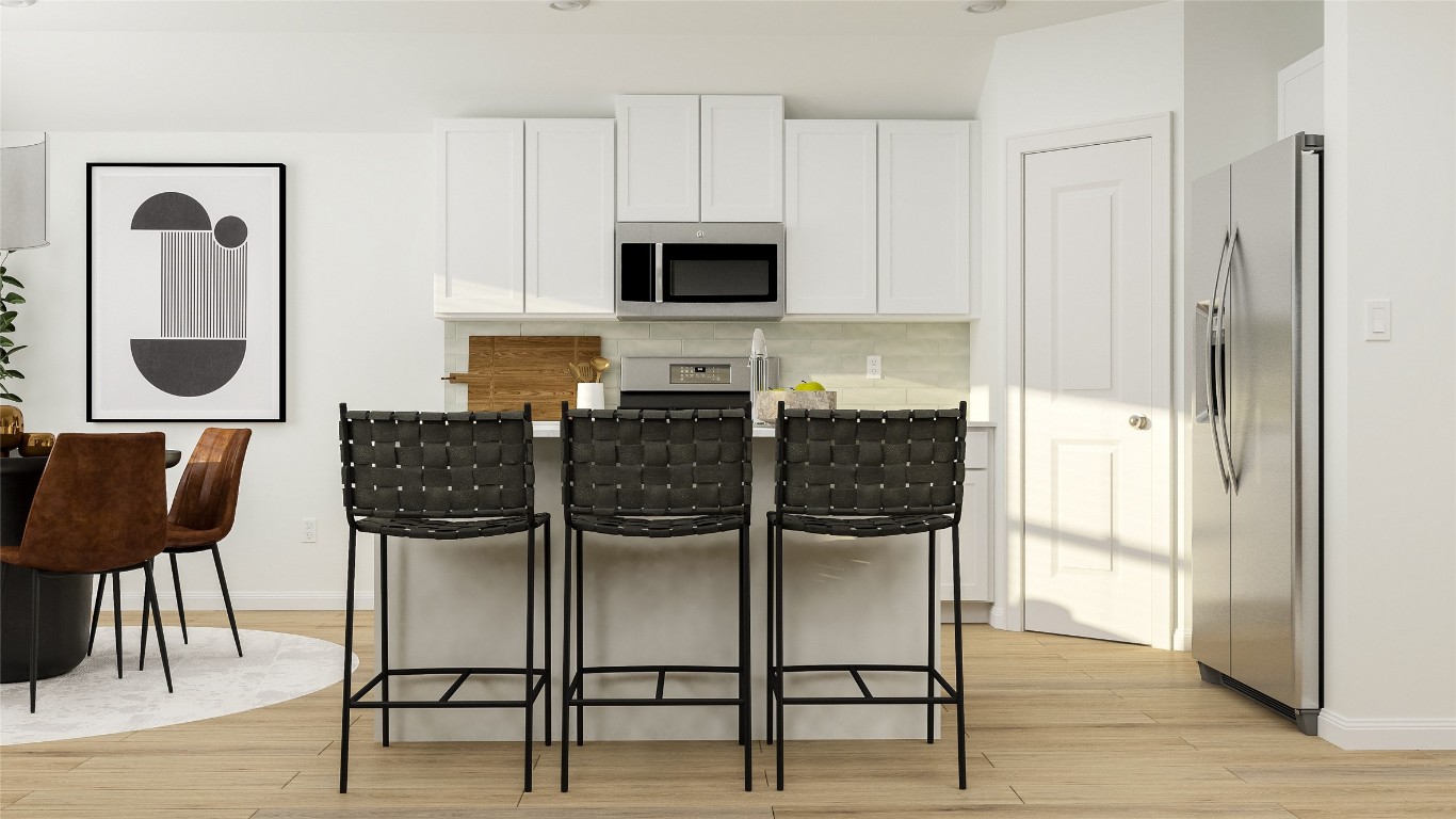 163 Avre Loop Kyle, TX 78640 - Photo 6 of 9 a kitchen with stainless steel appliances granite countertop a dining table chairs and a refrigerator