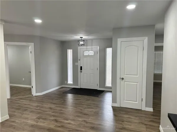 an empty room with wooden floor & closet area