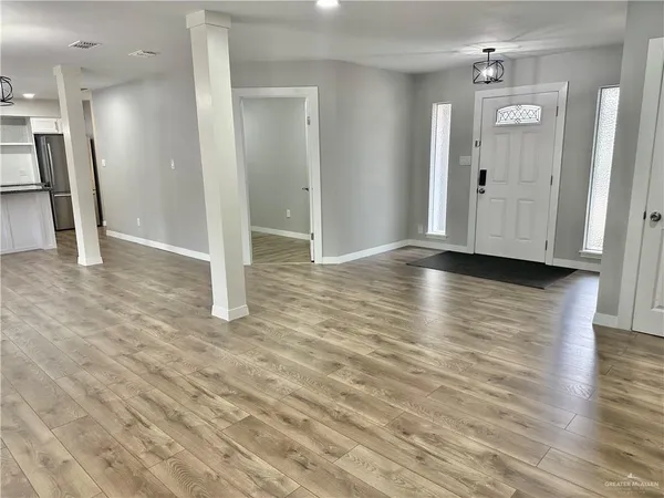 a view of empty room with wooden floor
