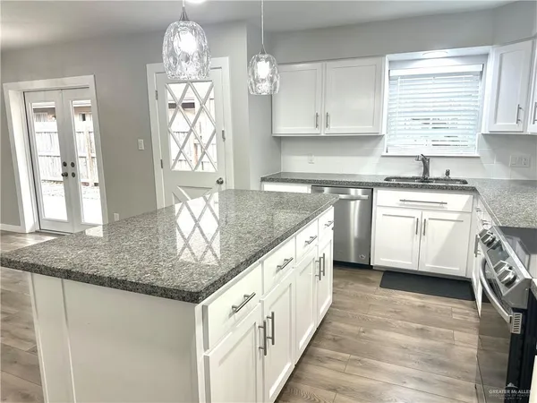 a kitchen with stainless steel appliances granite countertop a sink stove and cabinets