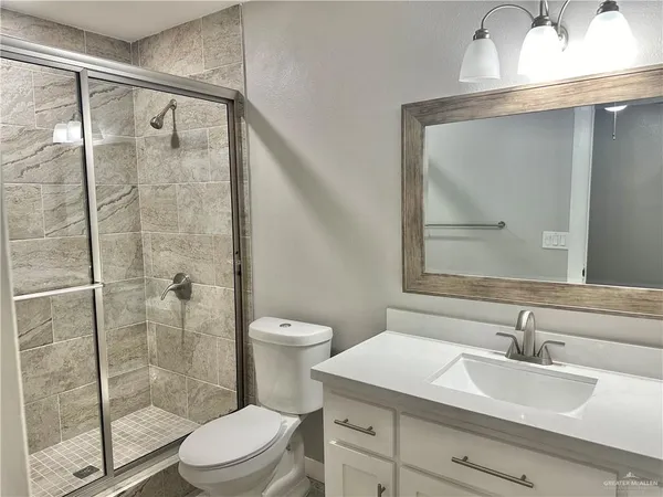 a bathroom with a sink a toilet and shower