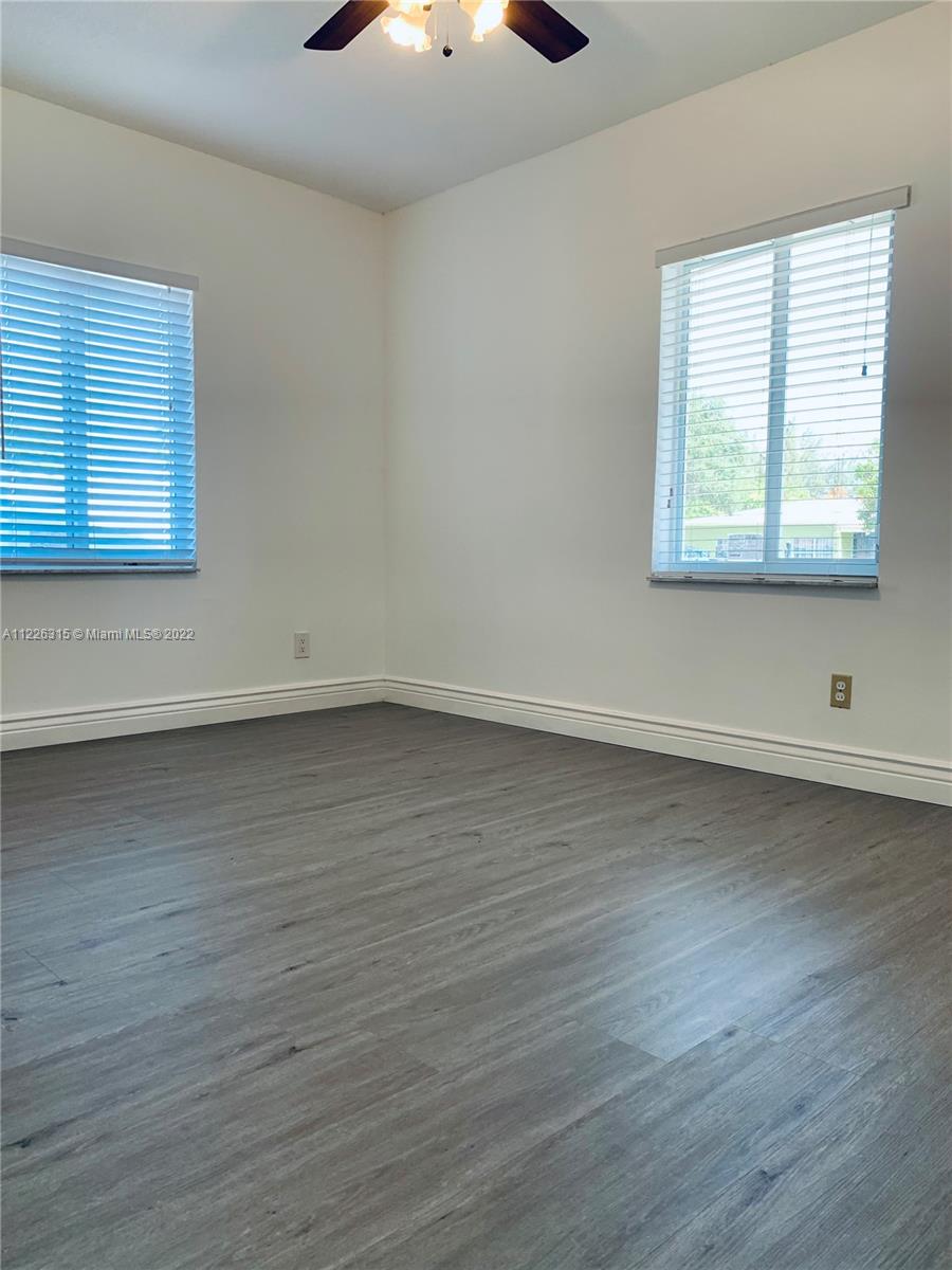 1315 Northwest 86th Street Miami, FL 33147 - Photo 4 of 16 an empty room with wooden floor and windows