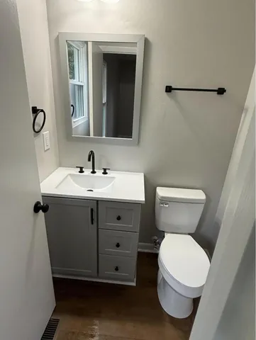 a bathroom with a toilet sink and mirror