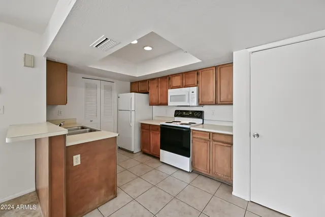 a kitchen with stainless steel appliances granite countertop a stove top oven a refrigerator a sink and dishwasher