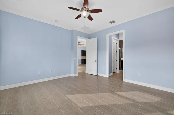 a view of an empty room and a ceiling fan window
