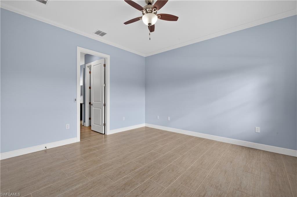 1412 Lucena Lane South Naples, FL 34113 - Photo 19 of 50 Primary bedroom with crown molding, tiled floors, and ceiling fan.