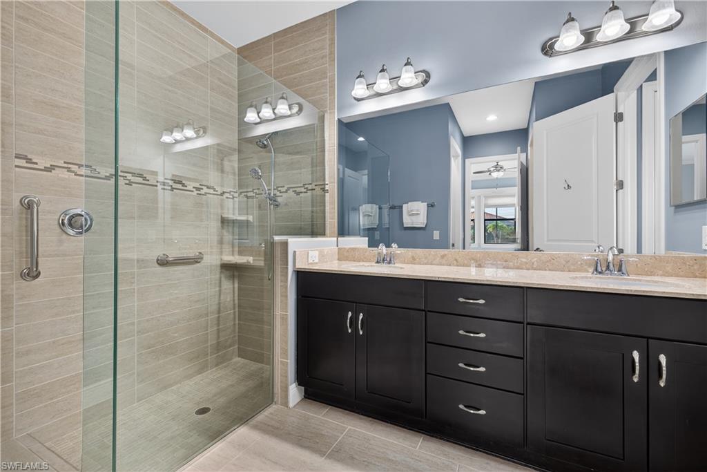 1412 Lucena Lane South Naples, FL 34113 - Photo 21 of 50 Primary bathroom featuring a large tiled walk in shower with listello, double vanity and private water closet.