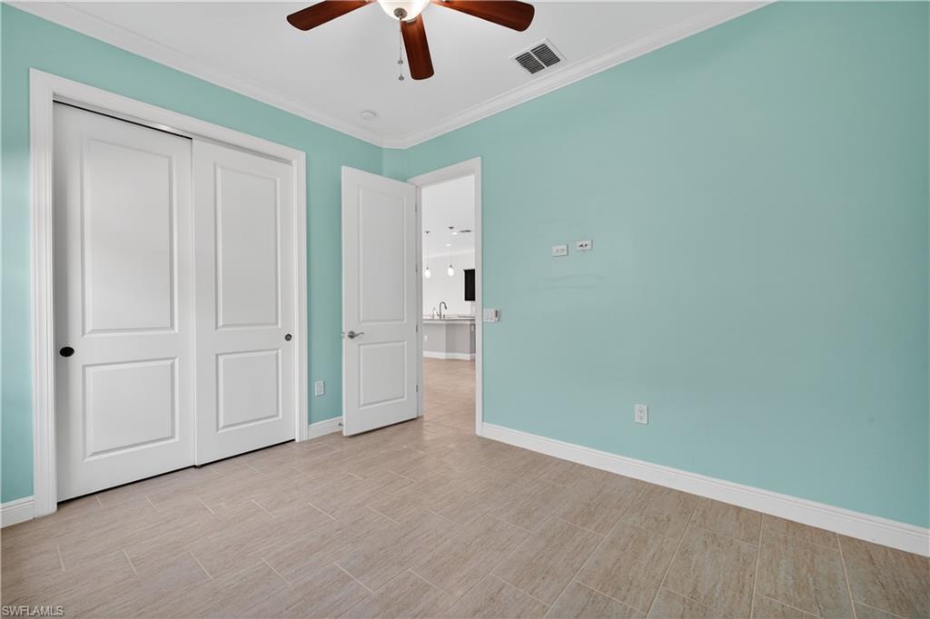 1412 Lucena Lane South Naples, FL 34113 - Photo 27 of 50 Guest bedroom with tile floors, crown molding and ceiling fan.