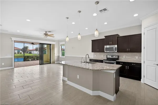 a large kitchen with stainless steel appliances granite countertop a large counter top and a stove top oven