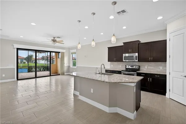 a large kitchen with a large counter top stainless steel appliances and cabinets