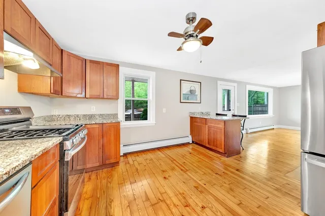 a kitchen with stainless steel appliances granite countertop a stove a sink dishwasher and a microwave oven with wooden floor