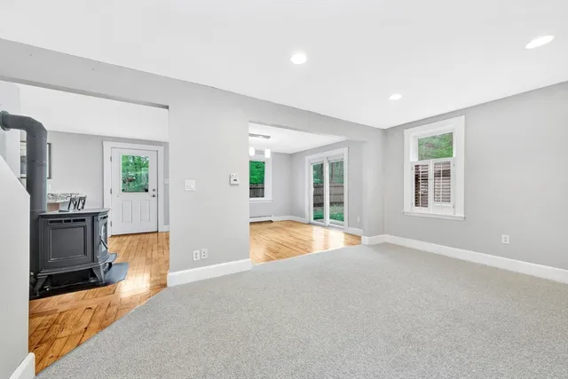 a view of an empty room with a fireplace and window