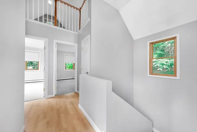 a view of hallway with wooden floor and windows