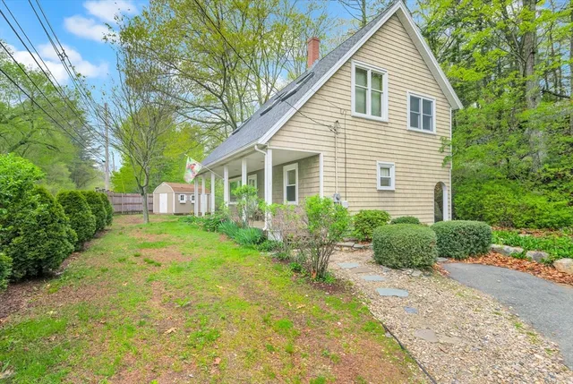 a front view of a house with a yard and trees