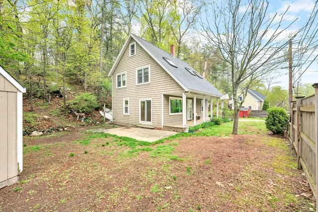 a view of a yard with a house and a large tree