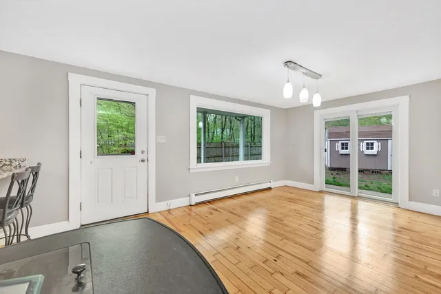 a view of an empty room with window and wooden floor