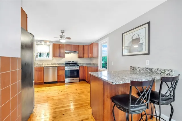 a kitchen with stainless steel appliances granite countertop a sink counter space and a refrigerator
