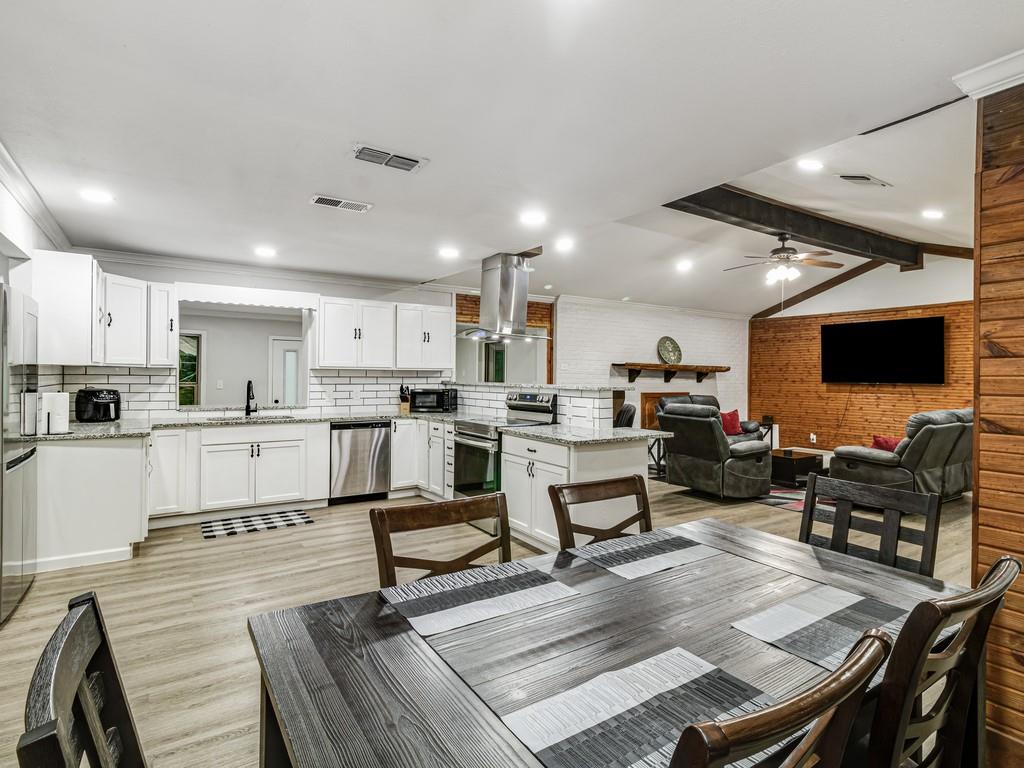203 Hogg Street Streetman, TX 75859 - Photo 12 of 36 a living room with stainless steel appliances furniture and a flat screen tv