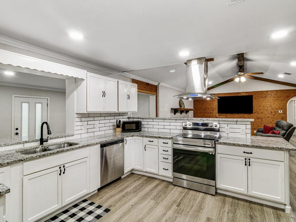 203 Hogg Street Streetman, TX 75859 - Photo 16 of 36 a kitchen with stainless steel appliances a stove sink and cabinets