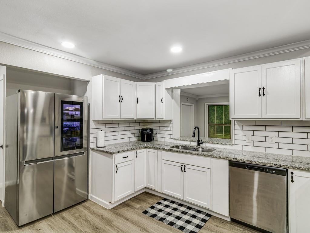 203 Hogg Street Streetman, TX 75859 - Photo 17 of 36 a kitchen with stainless steel appliances a sink stove and refrigerator