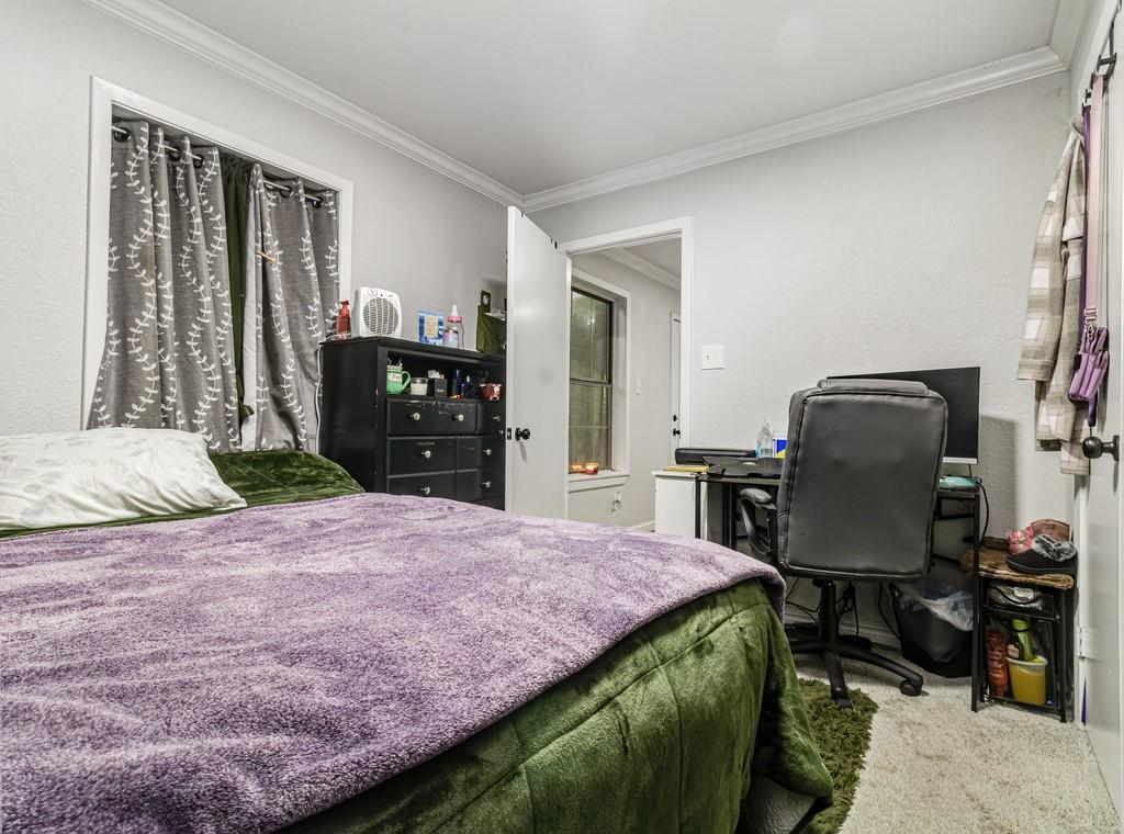 203 Hogg Street Streetman, TX 75859 - Photo 24 of 36 a bedroom with a bed and dresser with mirror