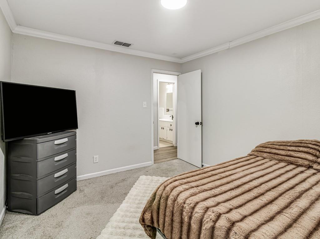 203 Hogg Street Streetman, TX 75859 - Photo 28 of 36 a bedroom with a bed and a flat screen tv