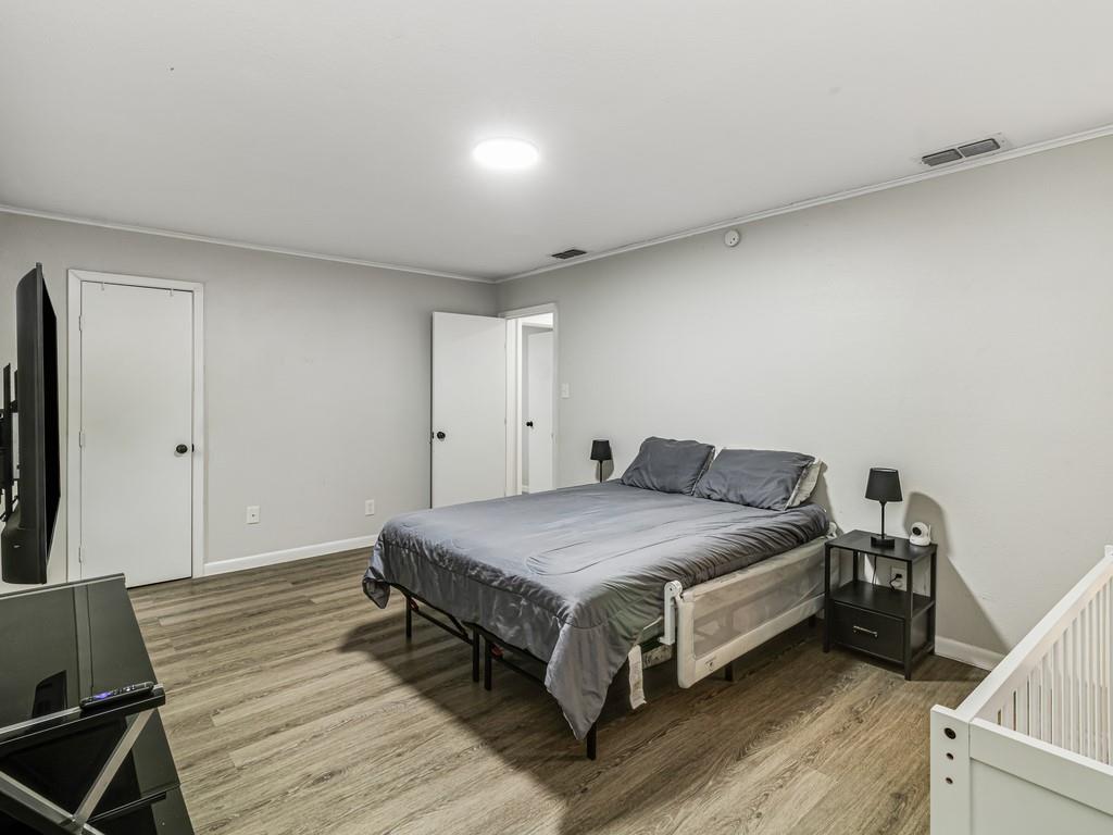 203 Hogg Street Streetman, TX 75859 - Photo 32 of 36 a spacious bedroom with a bed and a table